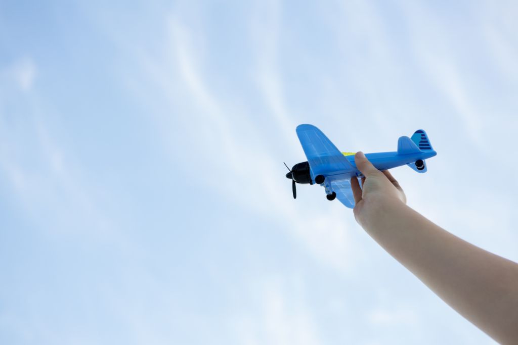 Hand playing with toy plane